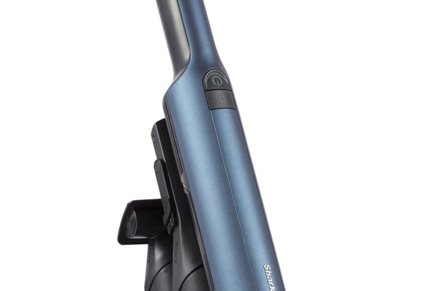 Een handstofzuiger in een stijlvolle blauwe kleur, bevestigd aan een oplaadstation voor gemakkelijk opladen en opslag. Deze compacte stofzuiger is ontworpen voor efficiënt schoonmaken van kleine ruimtes en oppervlakken.
