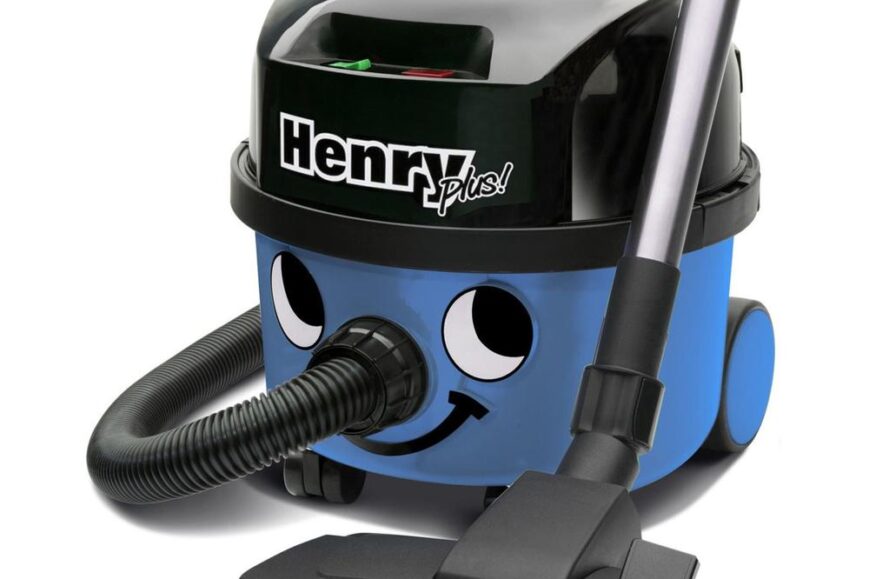 Een vrolijke blauwe stofzuiger met een glimlachend gezicht, het model Henry Plus. De stofzuiger heeft een zwarte bovenkant en een bijbehorende stofzuigerslang en mondstuk.