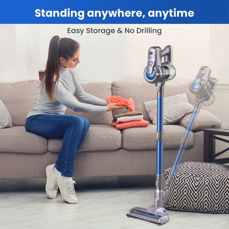Een vrouw zit op een bank en vouwt kleurrijke kleding terwijl een draadloze stofzuiger naast haar staat. De afbeelding benadrukt het gebruiksgemak van het apparaat met de tekst "Standing anywhere, anytime – Easy Storage & No Drilling".
