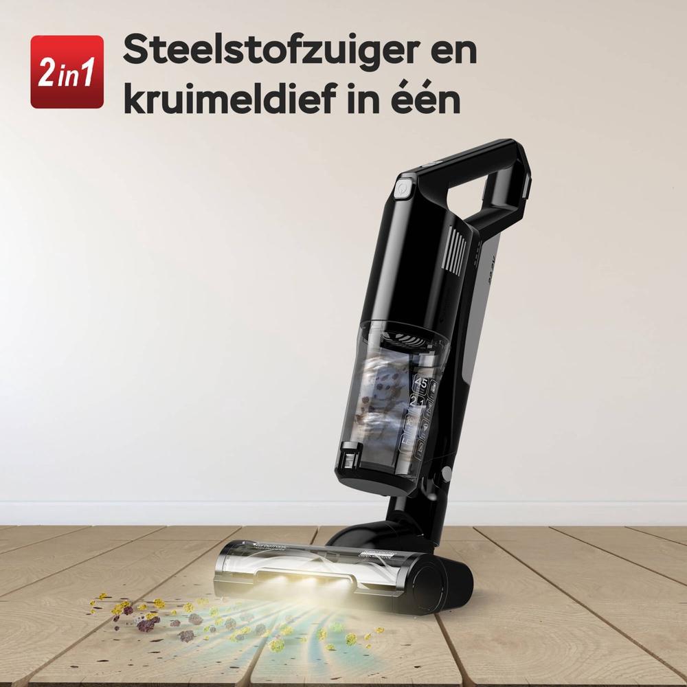 Een draadloze steelstofzuiger en kruimeldief in één, geplaatst op een houten vloer. De stofzuiger is uitgerust met een doorzichtige stofcontainer en verlicht de vloer terwijl het stof en kruimels opzuigt.