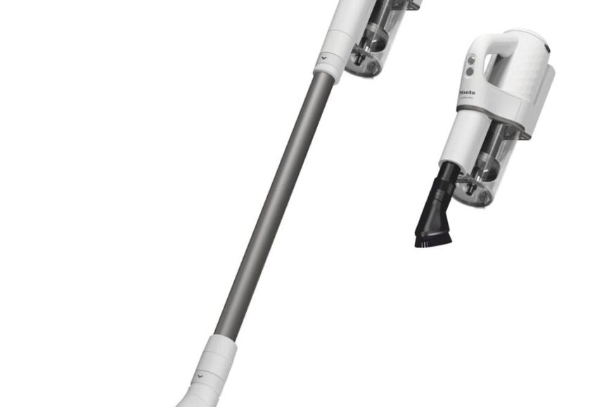 Draadloze stofzuiger met een opzetstuk voor kleine ruimtes en een afneembare handzuiger. De stofzuiger heeft een modern ontwerp in wit met een grijze steel en is geschikt voor veelzijdig gebruik.