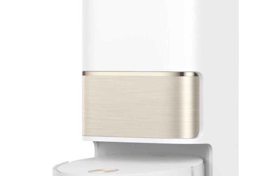 Een moderne robotstofzuiger van het merk Dreame staat in zijn oplader. De stofzuiger heeft een wit ontwerp met een metalen gouden accent aan de bovenkant.