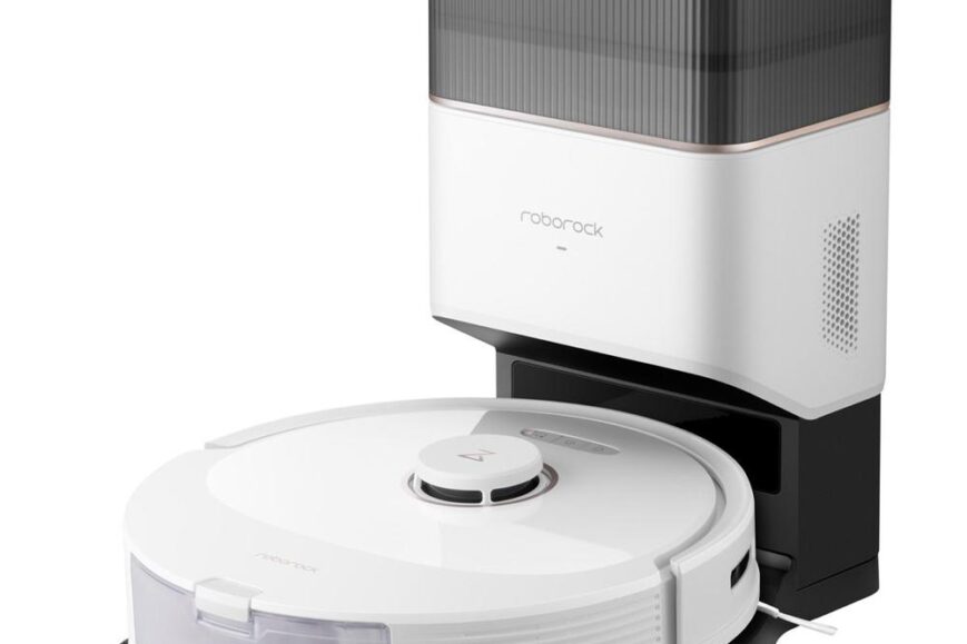 Een witte robotstofzuiger met een transparante opvangbak staat op een zwarte basis. Boven de stofzuiger bevindt zich een grijs-blauw apparaat dat dient als oplaadstation.