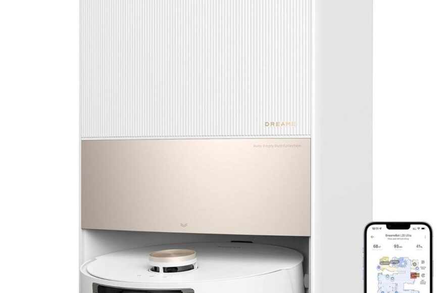 Een automatische stofzuiger met een elegante, witte en gouden afwerking staat in zijn dock met een smartphone erbij, die de reinigingsstatus toont. De afbeelding illustreert de technologie van het product en zijn gebruiksgemak voor efficiënte schoonmaak.