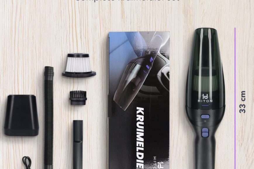 Afbeelding van de inhoud van een complete kruimeldief set. De set bevat de kruimeldief zelf, verschillende accessoires zoals een filter, slangen en een oplaadkabel, allemaal gepresenteerd op een lichte houten ondergrond.