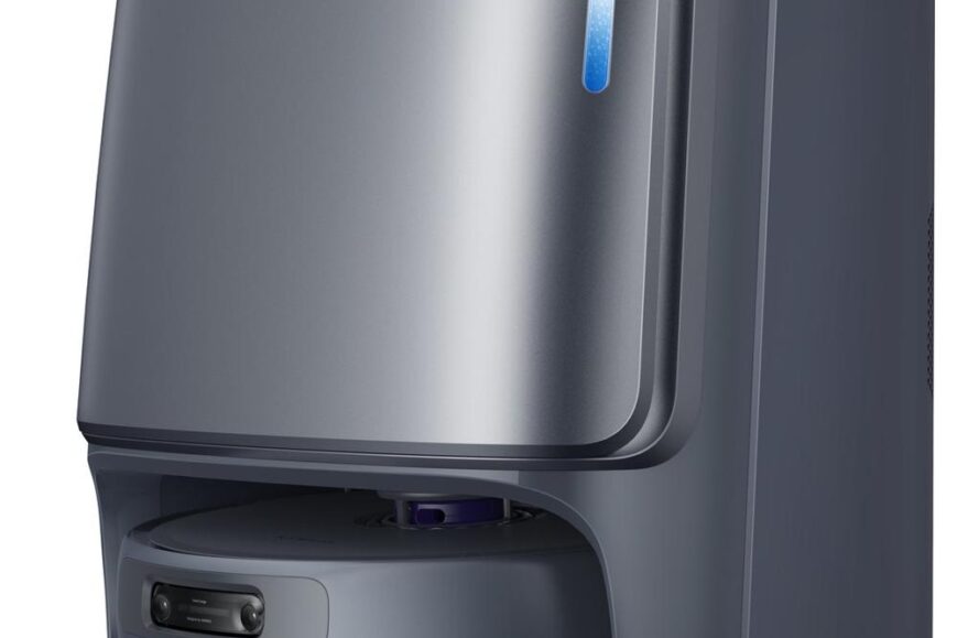 Een modern, robuust apparaat voor automatisering van schoonmaakwerkzaamheden, met een lichtblauwe indicator bovenop. Het heeft een afgeronde basis en een strak ontwerp in een grijze kleur, geschikt voor gebruik in huis.