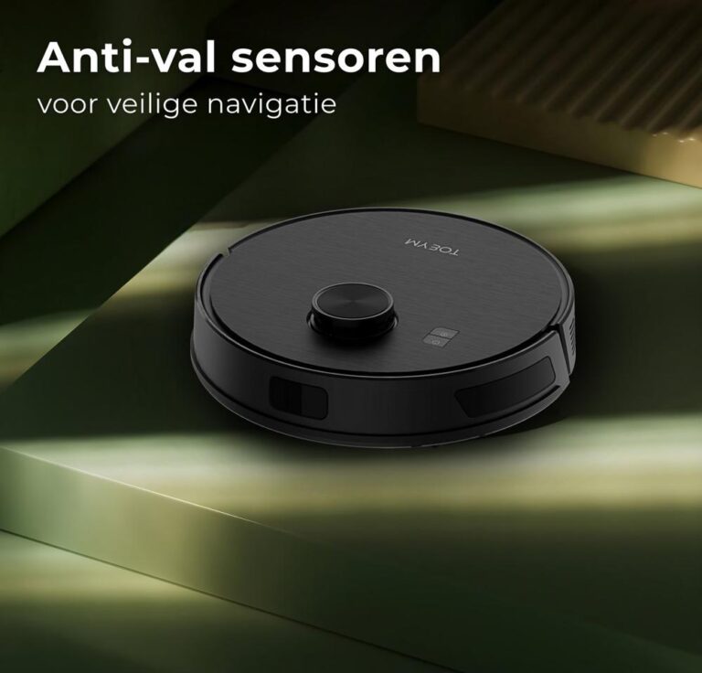 Een moderne robotstofzuiger ligt op een groene ondergrond, met de nadruk op zijn anti-val sensoren voor veilige navigatie. De stofzuiger heeft een cilindrische vorm en een stijlvolle, minimalistische uitstraling.