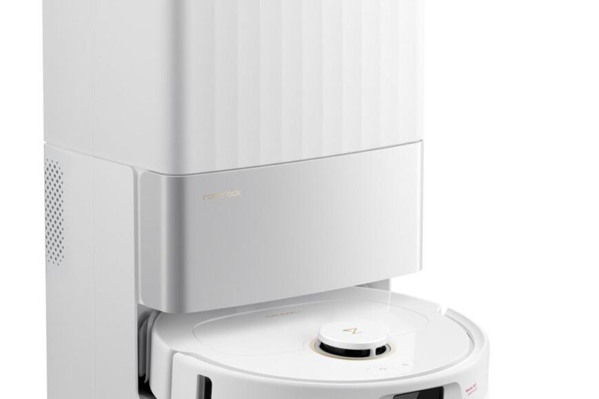 De afbeelding toont een witte robotstofzuiger met een compacte oplaadbasis, ontworpen voor automatische schoonmaak. Het apparaat heeft een modern en strak ontwerp met een stijlvol, rond oppervlak en een duidelijk zichtbaar bedieningspaneel.