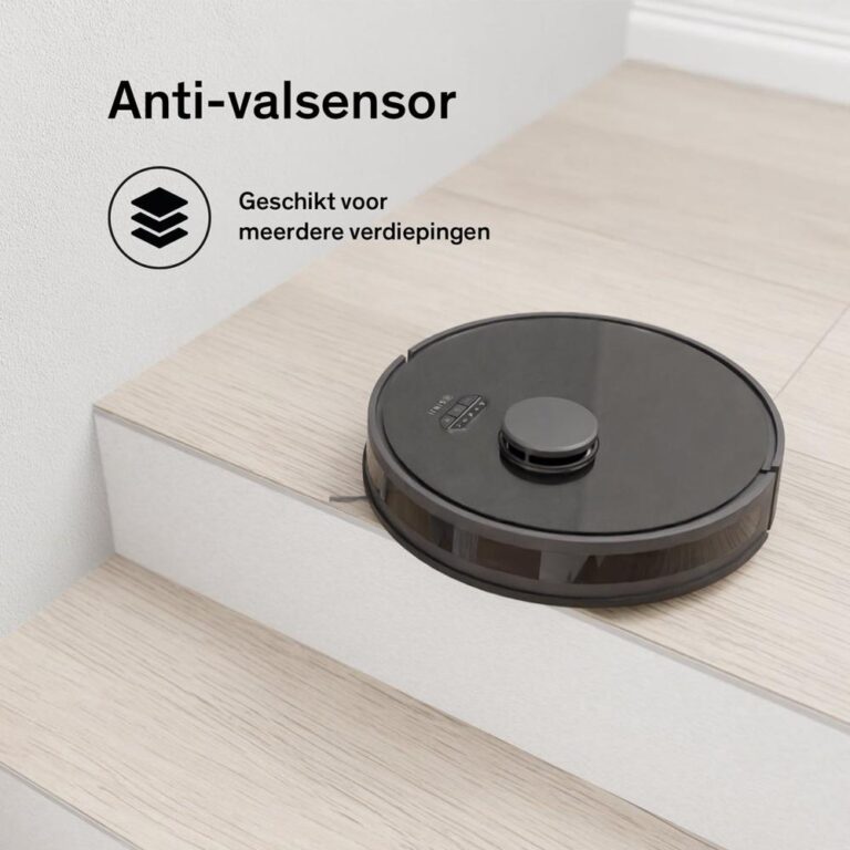 Een zwart robotstofzuiger staat op de rand van een trap, uitgerust met een anti-valsensor die voorkomt dat hij van de trap valt. De achtergrond toont een houten vloer en een lichte muur, terwijl de stofzuiger klaar is voor gebruik op meerdere verdiepingen.