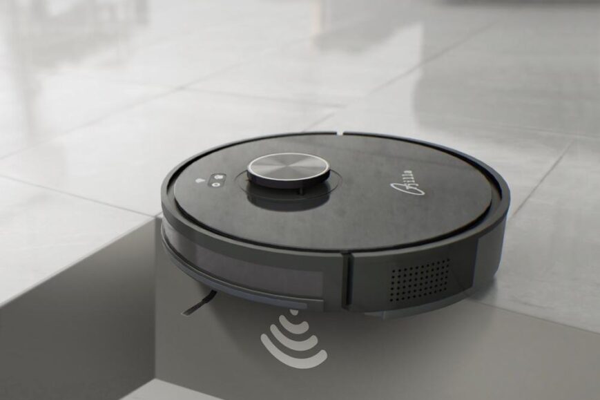 Een zwarte robotstofzuiger staat op de rand van een trap, met een zichtbaar anti-val sensortechnologie. De afbeelding toont de stofzuiger in een moderne omgeving, passend bij een review van slimme huishoudelijke apparaten.