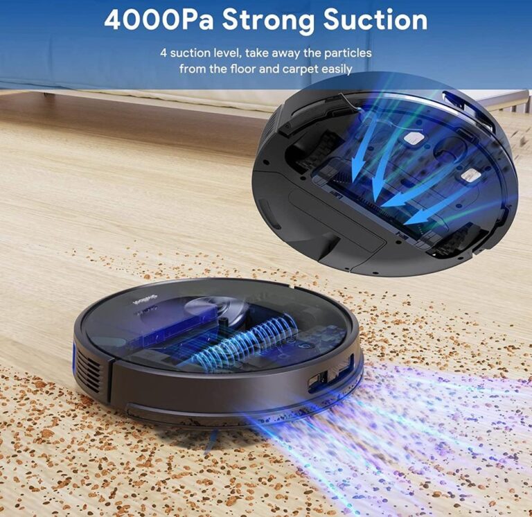 Een zwarte robotstofzuiger ligt op een houten vloer en verwijdert kruimels en stofdeeltjes. De afbeelding toont de krachtige zuigfunctie met visuele elementen die de luchtstroom aanduiden.