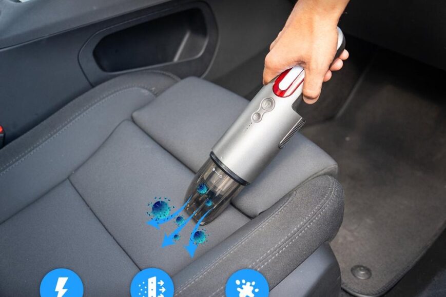 Draagbare stofzuiger in gebruik op een autobezitting, met een focus op het opzuigen van vuil en dierenhaar. De afbeelding benadrukt de krachtige motor en het gebruiksgemak voor het reinigen van kieren en moeilijk bereikbare plekken.