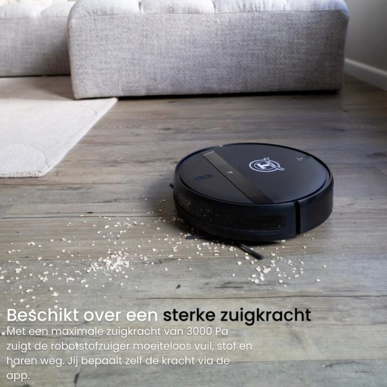 Een zwarte robotstofzuiger staat op een houten vloer met enkele korrels op de grond. De tekst benadrukt de sterke zuigkracht van 3000 Pa en de mogelijkheid om de kracht via een app aan te passen.