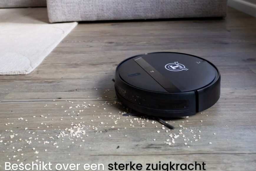 Een zwarte robotstofzuiger staat op een houten vloer met enkele korrels op de grond. De tekst benadrukt de sterke zuigkracht van 3000 Pa en de mogelijkheid om de kracht via een app aan te passen.