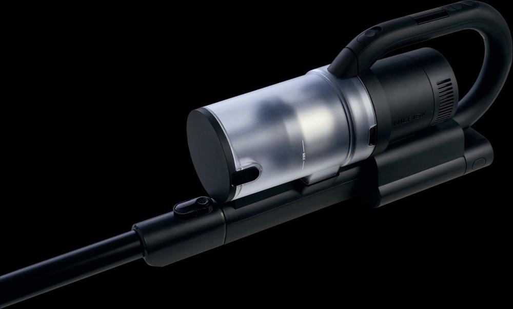 Een moderne stofzuiger met een duidelijk zichtbaar transparant stofreservoir en ergonomische handgreep. De stofzuiger heeft een zwart en metallic design en is geschikt voor het efficiënt schoonmaken van verschillende oppervlakken.