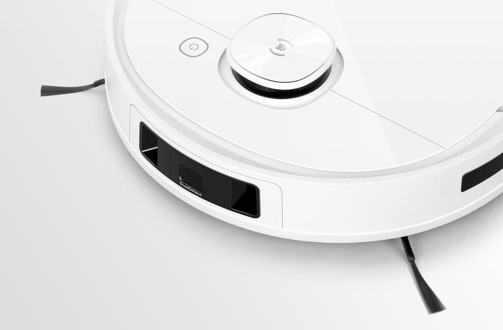 Witte robotstofzuiger met een minimalistisch ontwerp, uitgerust met een centraal bedieningspaneel en twee zijborstels aan de voorkant. De foto toont de robot op een lichte achtergrond, waardoor de details en functionaliteit goed zichtbaar zijn.