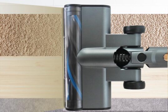 Afbeelding van een stofzuigerkop die geschikt is voor verschillende vloertypes, weergegeven op een achtergrond van diverse vloerafwerkingen zoals tapijt, houten vloer en tegels. De tekst "Geschikt voor iedere vloer" benadrukt de veelzijdigheid van het product.